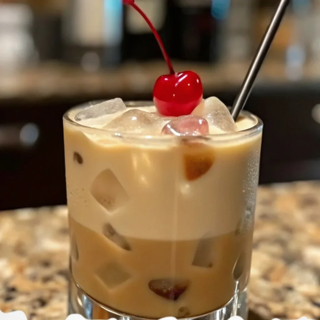 lippery Dick Cocktail with gin, grenadine, and citrus garnished with mint and cherry.