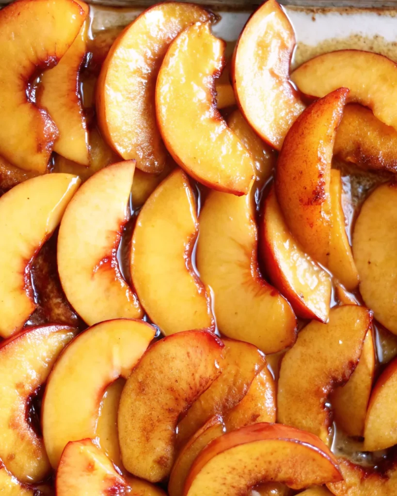 A beautifully baked peach galette with golden, flaky crust and neatly arranged fresh peach slices, served on a white plate.