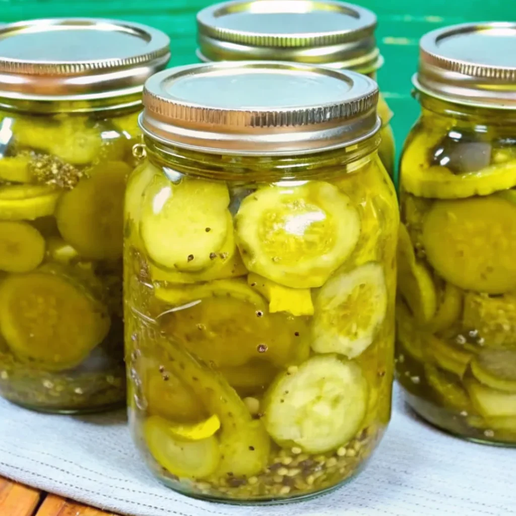 Homemade bread and butter pickles in glass jars, featuring sliced cucumbers and onions in a sweet and tangy brine, ready for canning or refrigeration.