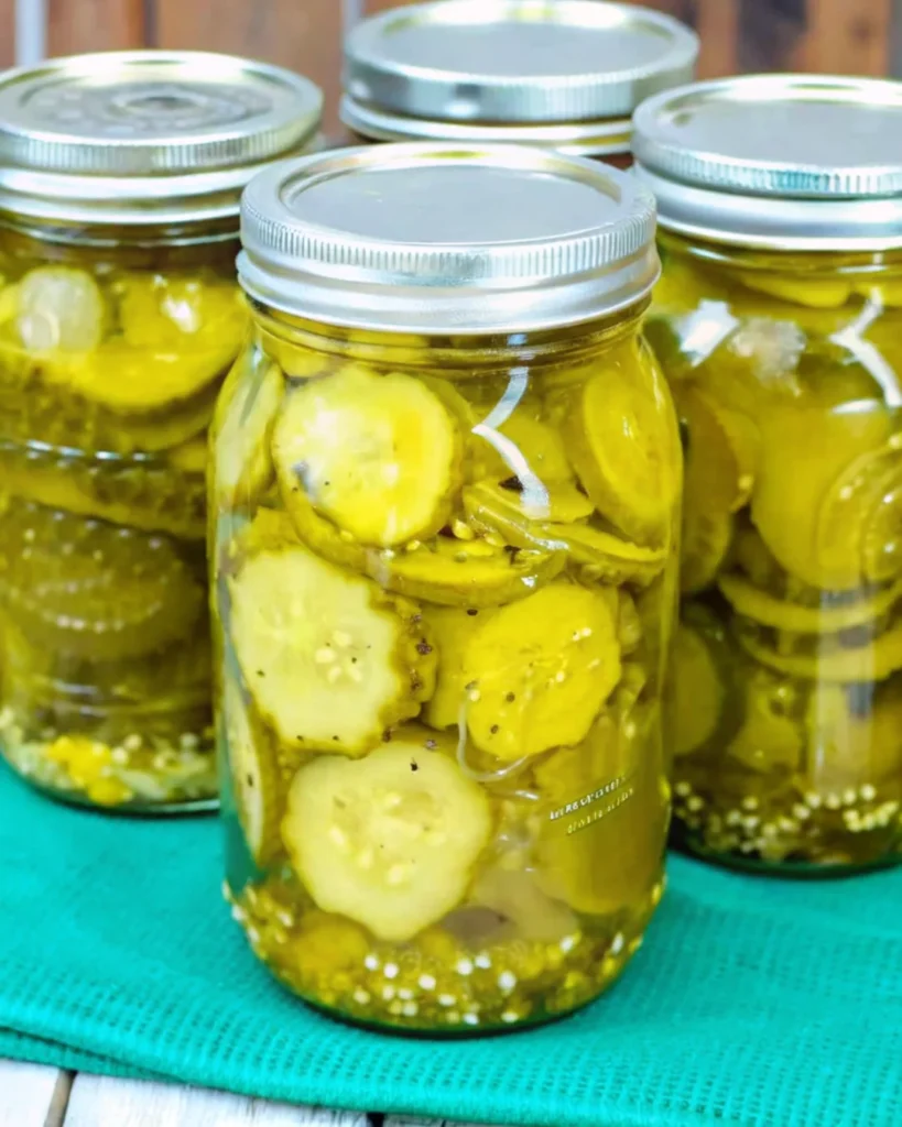 Homemade bread and butter pickles in glass jars, featuring sliced cucumbers and onions in a sweet and tangy brine, ready for canning or refrigeration.