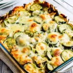 Easy Cheesy Zucchini Bake in a glass casserole dish, featuring golden, melted cheese over sliced zucchini, perfect for easy zucchini recipes and healthy family dinners.