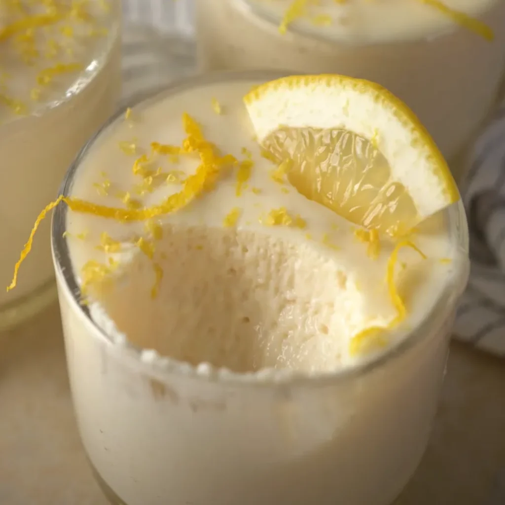 Creamy homemade lemon mousse served in a glass, topped with lemon zest and a lemon slice.