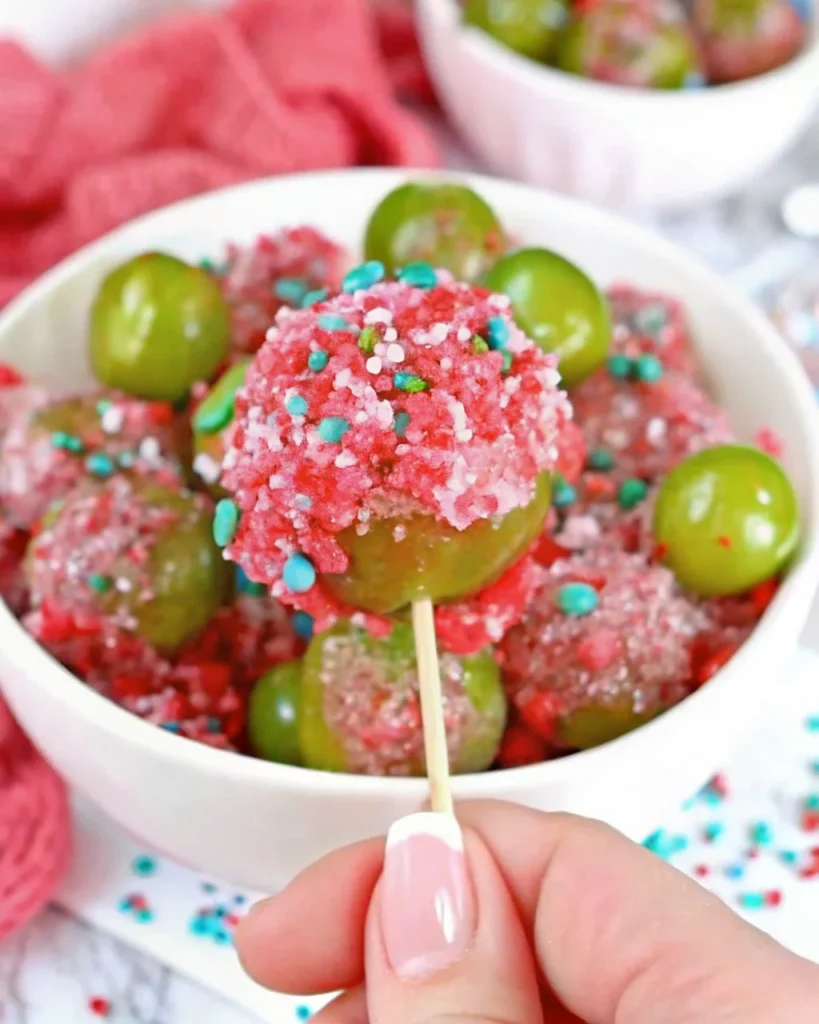 Colorful candy grapes coated in crushed Jolly Ranchers, displayed on a white plate