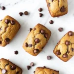 Freshly baked banana bread mini loaves with chocolate chips arranged on white marble surface, perfect mini loaf pan recipes for individual servings