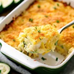 Freshly baked vegetable casserole with zucchini, golden-brown Parmesan crust, and herbs in a ceramic baking dish
