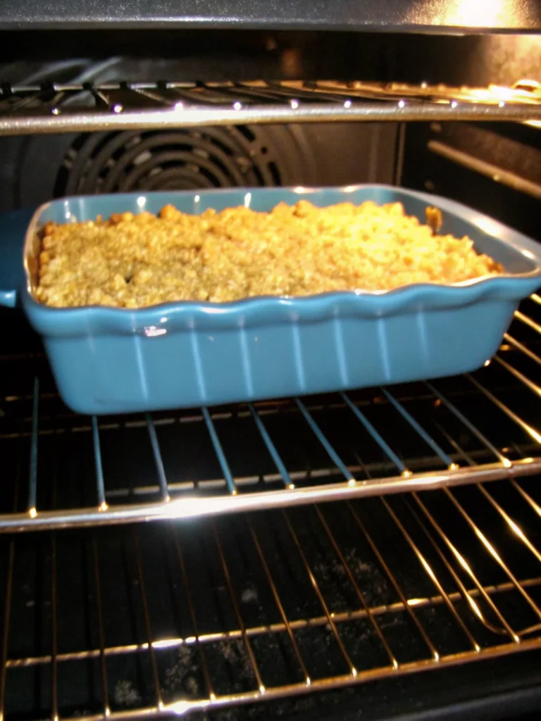 Homemade squash casserole with golden crushed Ritz crackers on top, showing creamy yellow squash filling underneath