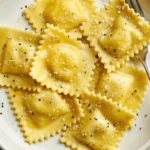 Hands kneading golden fresh ravioli pasta dough on wooden cutting board with flour and eggs nearby for homemade ravioli recipe