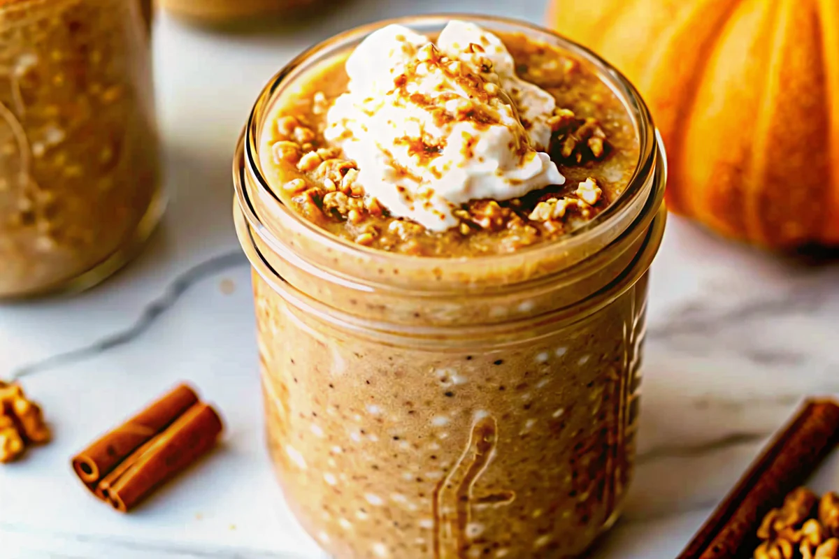 Creamy pumpkin pie overnight oats in mason jar topped with pecans and cinnamon for healthy fall breakfast meal prep