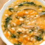 Best white bean soup recipe in rustic bowl with fresh herbs and olive oil drizzle, featuring cannellini beans, vegetables, and aromatic seasonings for healthy comfort food