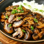 Savory Japanese miso mushrooms garnished with sesame seeds and green onions in a dark skillet, showcasing authentic japanese recipe ideas