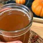 Easy homemade apple cider recipe with fresh apples, cinnamon sticks, and warming spices simmering in a large pot