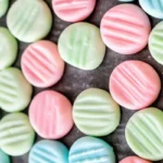 Homemade cream cheese mints arranged on white parchment paper showing classic crosshatch pattern made with fork tines, perfect for weddings and special events