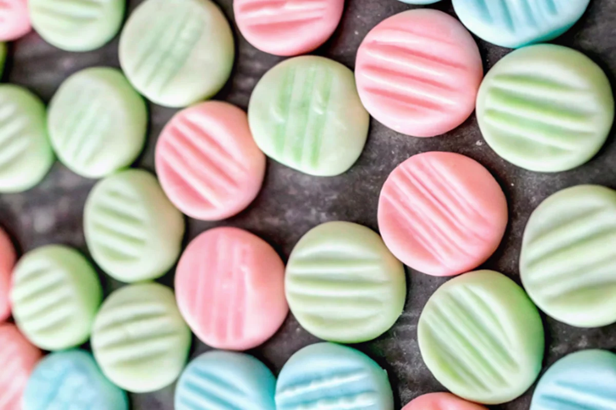 Homemade cream cheese mints arranged on white parchment paper showing classic crosshatch pattern made with fork tines, perfect for weddings and special events