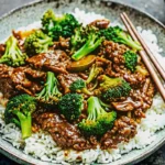 Chinese Beef and Broccoli stir fry in black skillet with tender beef strips, bright green broccoli florets, and glossy brown sauce, ready to serve over rice