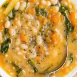 Creamy white bean soup with rosemary and vegetables in a rustic bowl, garnished with olive oil and fresh herbs