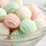 Homemade cream cheese mints recipe with fork-pressed ridges on parchment paper, showing soft pastel colored wedding mints and baby shower mints ready to serve