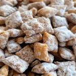 Caramel Apple Puppy Chow Recipe in white bowl with apple pieces and cinnamon coating