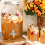 Caramel Apple Punch in glass bowl with sliced apples and cranberries for fall party