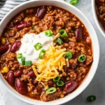 Easy chili recipe crockpot with ground beef, beans, and tomatoes cooking in slow cooker, perfect comfort food meal