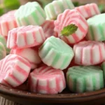 Colorful homemade cream cheese mints arranged on white parchment paper showing pink, green, and white mint candies made from the perfect cream cheese mints recipe
