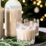 Homemade Baileys Irish Cream in glass bottle with ingredients including Irish whiskey, heavy cream, and chocolate syrup on rustic wooden table