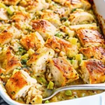 Golden brown chicken and stuffing casserole in white baking dish with melted cheese and herbs, comfort food recipe