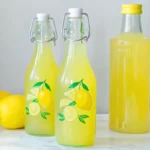 Homemade limoncello recipe ingredients including organic lemons, high-proof alcohol, and sugar arranged on rustic Italian kitchen counter