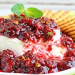 Fresh homemade cranberry sauce with orange juice in glass bowl, featuring ruby red cranberries and citrus garnish for holiday meals