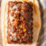 Sliced Amish Apple Fritter bread with glaze drizzle showing moist crumb texture and apple pieces