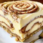 Delicious Cinnamon Roll Cheesecake with gooey cinnamon swirls and creamy frosting – perfect homemade cinnamon cheesecake recipe for desserts.